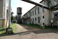 L'usine, façade amont de la salle des machines et du moulin. Château d'eau.