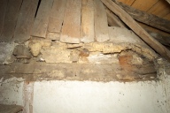 Plancher du comble et cloison de bois vus depuis la cage d'escalier.