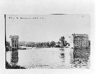 Vue d'ensemble du site depuis la rive droite en aval après 1913 : façade sud du moulin du Grand Pendu, pertuis, barrage, façade sud du moulin du Petit Pendu.