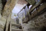 Moulin de Drézeux. Intérieur de la tourelle. Le petit escalier en angle menant à l'étage. De part et d'autre, les deux cadres en bois de la trempure.
