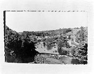 Vue aérienne de l'ensemble du site. Au premier plan, l'ancien barrage des Communes. Au second, l'ancien barrage de Morand. Au fond, le village et le pont de Montgiroux. A droite, le canal.