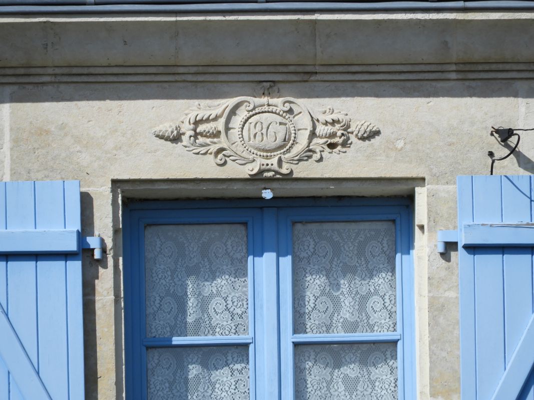 La date 1867 inscrite dans un cartouche au sommet de la façade.