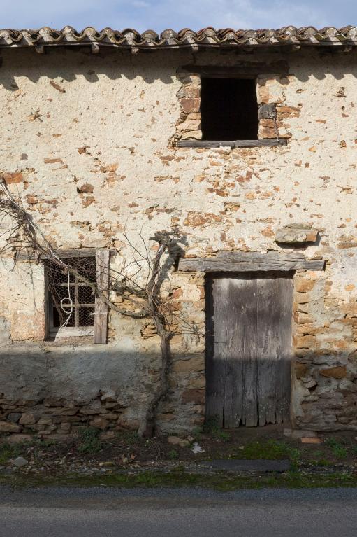 Façade principale d'une ancienne habitation. Les murs sont en pierre de schiste montés à la terre. Les baies et la porte sont surmontées d'un linteau de bois. La Mauvillonnière, La Planche.