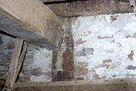 Détail du pan de bois du mur nord de l'ancien logis : la sablière, le poteau et l'entrait vus depuis l'intérieur.